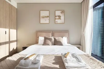 a bedroom with a large bed with two slippers on it at Brand New Luxury Waterfront 2bd Beautiful Canal View in Dubai