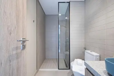 a bathroom with a shower with a toilet and a sink at Brand New Luxury Waterfront 2bd Beautiful Canal View in Dubai