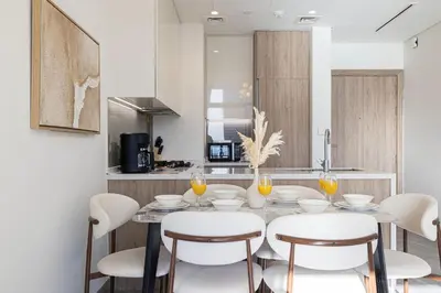 a dining room with a table and chairs and a kitchen at Brand New Luxury Waterfront 2bd Beautiful Canal View in Dubai