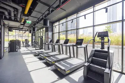 a row of treadmills in a gym with windows at Brand New Luxury Waterfront 2bd Beautiful Canal View in Dubai