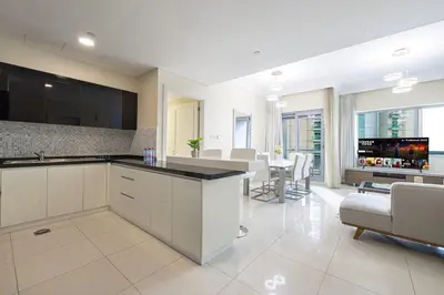 a kitchen with a living room and a dining room at Damac Maison Mall Street! Upgraded 3 Bedroom with Burj and DIFC views! Nearest to Dubai Mall in Dubai