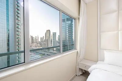 a bedroom with a window with a view of the city at Damac Maison Mall Street! Upgraded 3 Bedroom with Burj and DIFC views! Nearest to Dubai Mall in Dubai