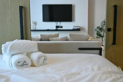 a hotel room with towels on a bed with a couch at Luxury 1BR Apartment - DAMAC Hills - Infinity Pool in Dubai