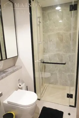 a bathroom with a toilet and a glass shower at Luxury 1BR Apartment - DAMAC Hills - Infinity Pool in Dubai