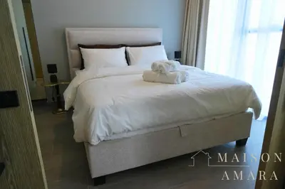 a bedroom with a bed with a stuffed animal on it at Luxury 1BR Apartment - DAMAC Hills - Infinity Pool in Dubai