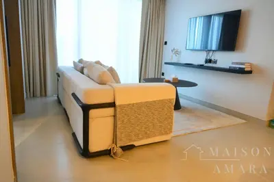 a living room with a couch and a table at Luxury 1BR Apartment - DAMAC Hills - Infinity Pool in Dubai