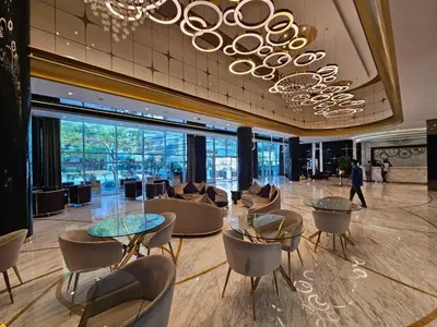 a lobby with tables and chairs and a chandelier at Sunrise Homes A Beautiful Studio in Downtown in Dubai