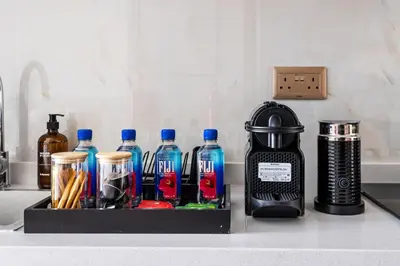 a kitchen counter with a tray with bottles on it at Cozy Studio with 31st Floor Miracle Garden View in Dubai