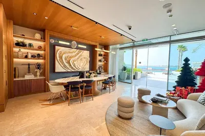 a living room with a table and chairs and a couch at PVH - Ellington Beach House - Luxurious 1BR with Private Beach Access in Dubai