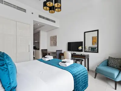a bedroom with a bed and two chairs and a desk at Relaxing Stay Studio in Ghalia 29 in Dubai