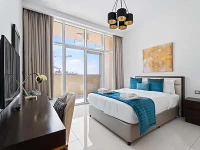 a bedroom with a bed and a desk and a window at Relaxing Stay Studio in Ghalia 29 in Dubai