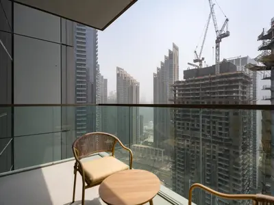 a chair on a balcony with a view of a city at Grande Essence Elegant 1BR Sleeps 4 in Downtown in Dubai