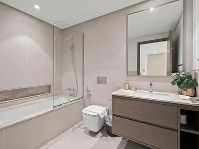 a bathroom with a toilet and a sink and a mirror at Grande Essence Elegant 1BR Sleeps 4 in Downtown in Dubai