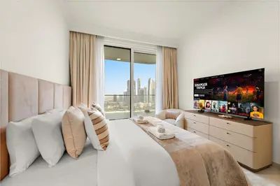 a bedroom with a large bed with a flat screen tv at Luxe 2BR with Full Marina Views & Beach Access in Dubai