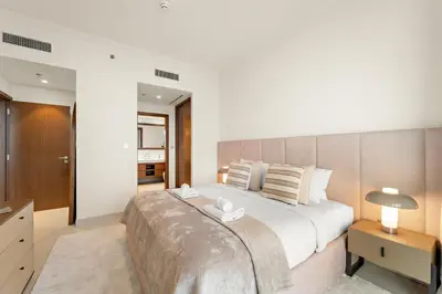 a bedroom with a large bed with a large headboard at Luxe 2BR with Full Marina Views & Beach Access in Dubai