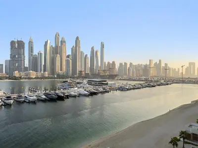 a group of boats docked in a harbor with a city at Luxe 2BR with Full Marina Views & Beach Access in Dubai