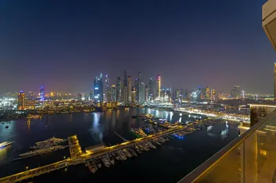 a view of a city at night with a harbor at Luxe 2BR with Full Marina Views & Beach Access in Dubai