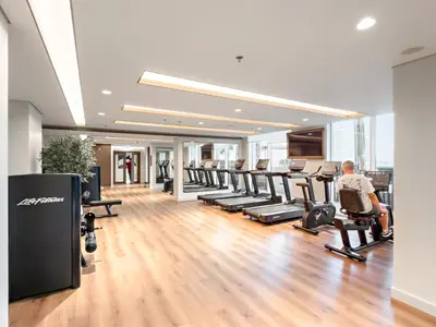 a gym with a row of treadmills and machines at Luxe 2BR with Full Marina Views & Beach Access in Dubai