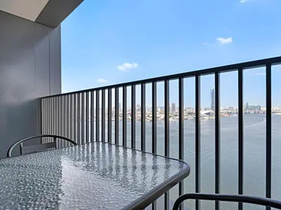 a table on a balcony with a view of the water at Creek Harbour Gem Stylish 2BR with Stunning Views-17 in Dubai