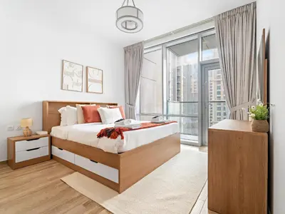 a bedroom with a bed and a large window at Charming City View w 1BDR Apartment In Noura Tower in Dubai