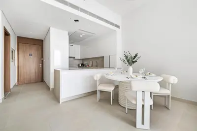 a white kitchen with a white table and chairs at 2BR plus M CF7 B Partial Canal View in Dubai