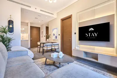 a living room with a couch and a tv at STAY BY LATINEM Luxury 1BR Holiday Home CB 0618 Near Burj Khalifa in Dubai