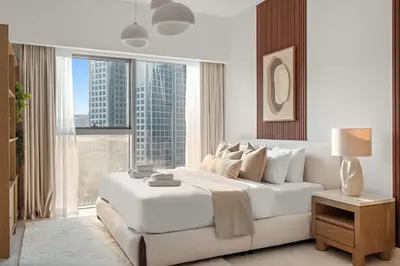 a white bedroom with a large bed and a large window at Silkhaus Entrepreneur Work & Stay Studio in DIFC in Dubai