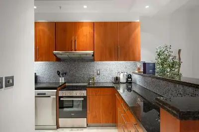 a kitchen with wooden cabinets and a stove at Silkhaus Entrepreneur Work & Stay Studio in DIFC in Dubai