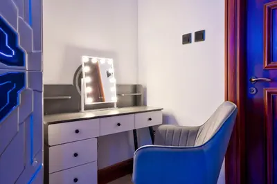 a dressing table with a mirror and a blue chair at Teremok Holiday Homes in Dubai