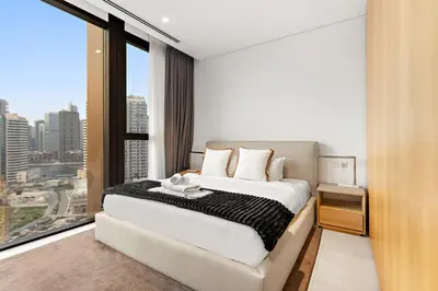 a bedroom with a large bed and a large window at Spacious 2BR in Business Bay with Canal View in Dubai