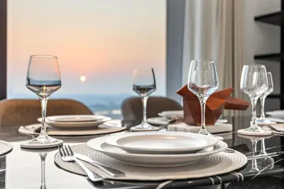 a table with plates and wine glasses on it at Spacious 2BR in Business Bay with Canal View in Dubai