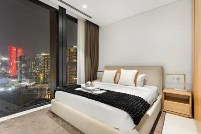 a bedroom with a large window with a city skyline at Spacious 2BR in Business Bay with Canal View in Dubai