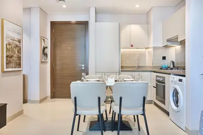 a kitchen with a table and chairs in a kitchen at STAY BY LATINEM Luxury 1BR Holiday Home CV A 907 near Dubai Mall in Dubai