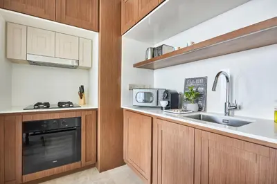 a kitchen with wooden cabinets and a sink and a microwave at Frank Porter - Palace Beach Residence in Dubai