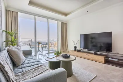 a living room with a large television and a couch at Frank Porter - Palace Beach Residence in Dubai