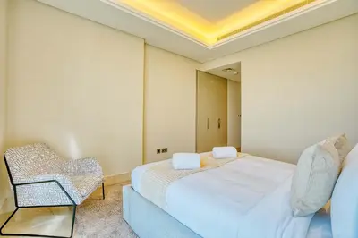 a bedroom with a bed and a chair in it at PVH - The 8 - Opulent 3BR with Sea View and Private Beach Access in Dubai