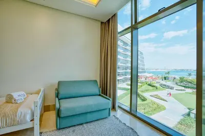 a room with a chair and a large window at PVH - The 8 - Opulent 3BR with Sea View and Private Beach Access in Dubai