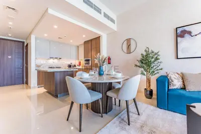 a kitchen and living room with a table and chairs at High-Floor Balcony with Burj Khalifa View and Assistant Room, Minutes from Burj Plaza & Dubai Mall, Easy Access to Downtown Attractions, Imperial Avenue, Downtown Dubai by Deluxe Holiday Homes in Dubai