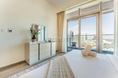 a white bedroom with a large window at High-Floor Balcony with Burj Khalifa View and Assistant Room, Minutes from Burj Plaza & Dubai Mall, Easy Access to Downtown Attractions, Imperial Avenue, Downtown Dubai by Deluxe Holiday Homes in Dubai
