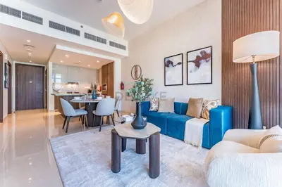 a living room with a blue couch and a table at High-Floor Balcony with Burj Khalifa View and Assistant Room, Minutes from Burj Plaza & Dubai Mall, Easy Access to Downtown Attractions, Imperial Avenue, Downtown Dubai by Deluxe Holiday Homes in Dubai