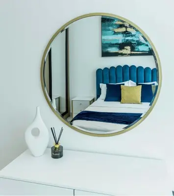 a bedroom with a blue bed and a mirror at Sleeps 4 I Circle Mall I Epic Pool in Dubai
