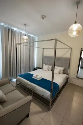 a bedroom with a canopy bed and a couch at Downtown 1BHK apartment with City view in Dubai