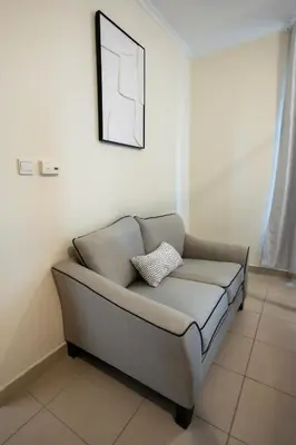 a couch in a room with a picture on the wall at Downtown 1BHK apartment with City view in Dubai