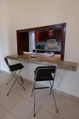 a kitchen with two chairs and a counter with a counter top at Downtown 1BHK apartment with City view in Dubai