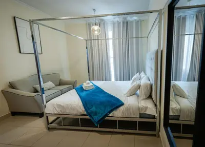 a bedroom with a canopy bed and a chair at Downtown 1BHK apartment with City view in Dubai