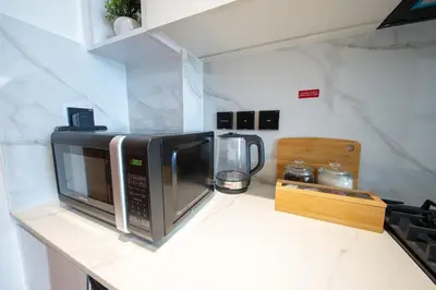a microwave sitting on a counter in a kitchen at Private Pool I Sleeps 6 I 5 Star Amenities I 2BR Onyx in Dubai