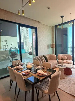 a dining room with a table and chairs and a couch at Private Pool I Sleeps 6 I 5 Star Amenities I 2BR Onyx in Dubai