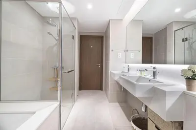 a bathroom with two sinks and a shower at Canal Front Luxe, Elegant 2BR with Water Views in Dubai