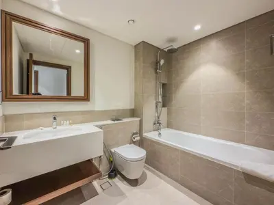 a bathroom with a tub and a toilet and a sink at Dubai Harbour Marina View with Beach Access in Dubai
