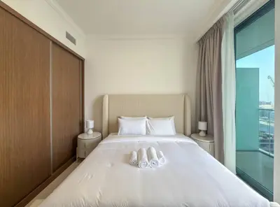 a bedroom with a white bed with a large window at Dubai Harbour Marina View with Beach Access in Dubai